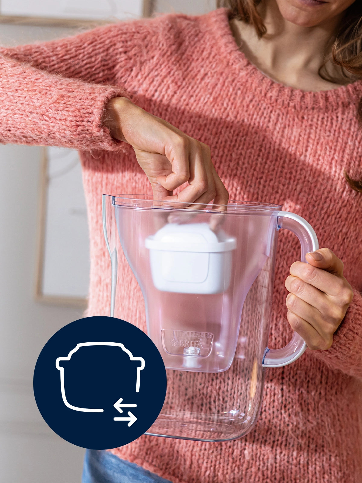 Person inserting BRITA MAXTRA filter cartridge in Water Filter Jug with filter exchange icon on a blue circle.